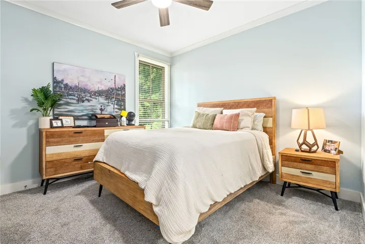 A well-lit bedroom with comfortable carpeting offers a serene retreat.