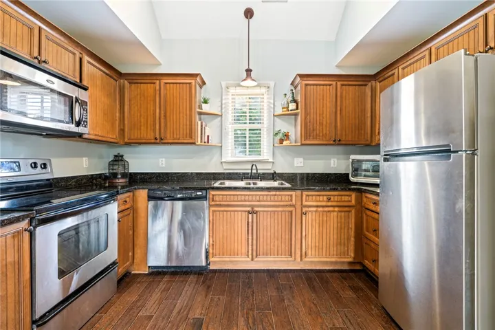 A well-equipped kitchen features dark wood cabinetry, durable countertops, and stainless steel appliances.
