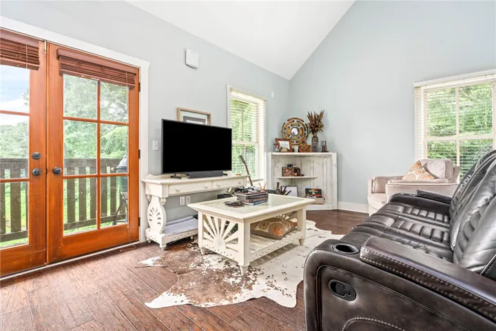 Rich hardwood floors complement the natural light streaming through expansive windows in this inviting living area.
