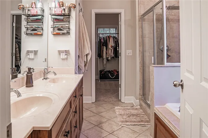 Double vanity with ample counter space and a convenient walk-in closet for seamless daily routines.