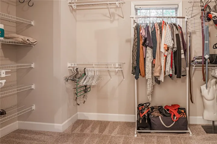 Organized wire shelving and clothing racks provide ample storage in this well-appointed closet.