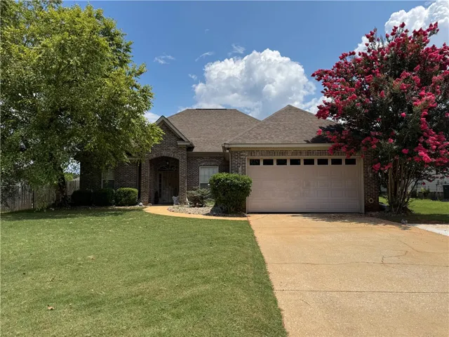 A well-maintained brick exterior and neatly manicured landscaping greet visitors to this inviting home.