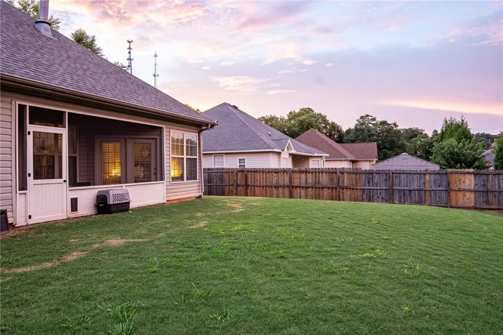 A neatly manicured backyard with a wooden fence offers a private outdoor haven.