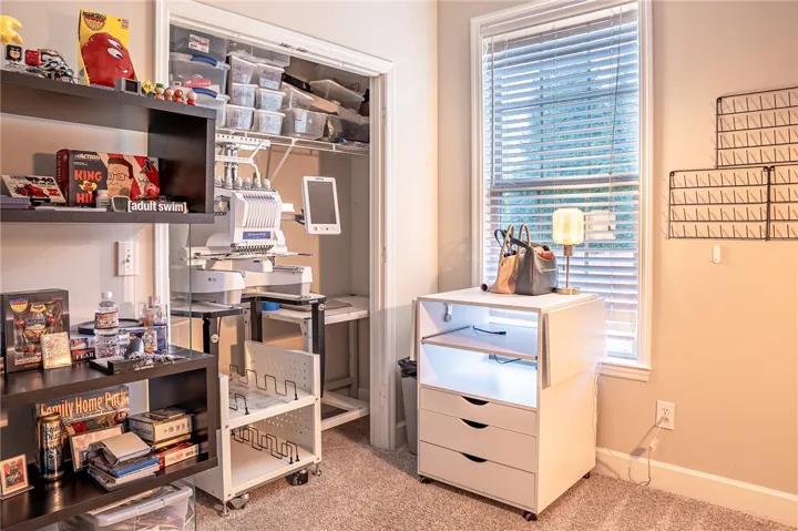 A well-lit, dedicated craft room offers organized shelving and a functional workspace.