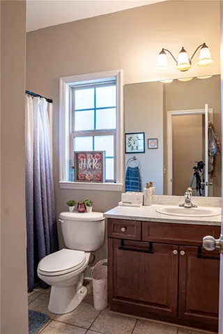A well-appointed bathroom with a window above the commode and a practical vanity.