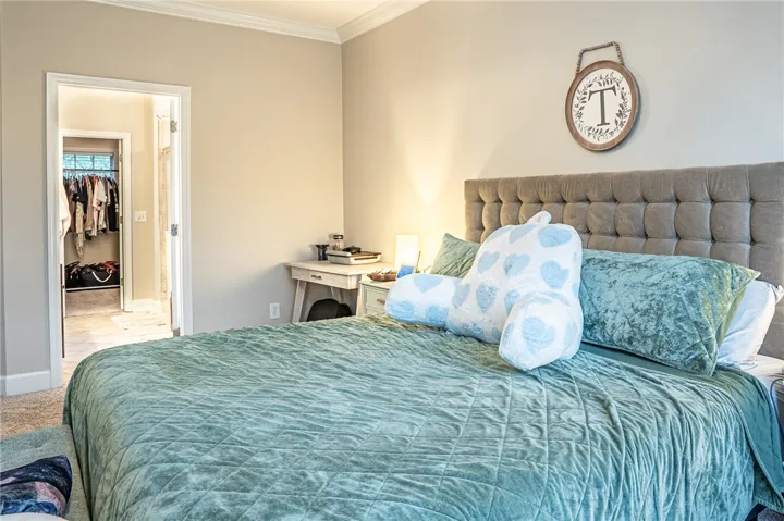 A well-appointed bedroom features plush carpeting and convenient access to a walk-in closet, blending comfort with practicality.