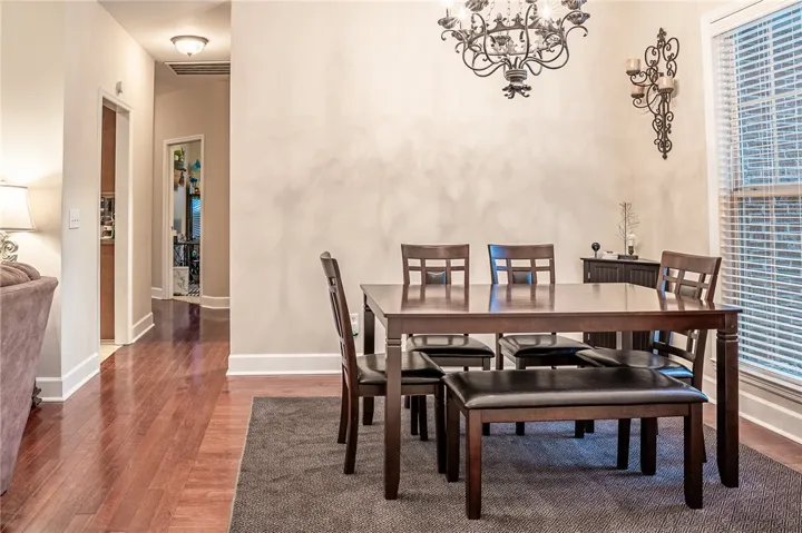 Elegant dining area featuring hardwood flooring and a decorative chandelier, perfect for entertaining.