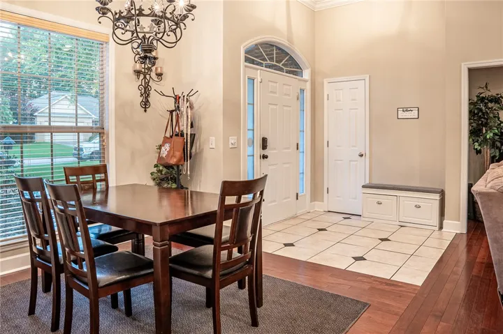 An inviting foyer with patterned tile flooring transitions seamlessly to warm hardwood, welcoming guests with a stylish built-in bench.
