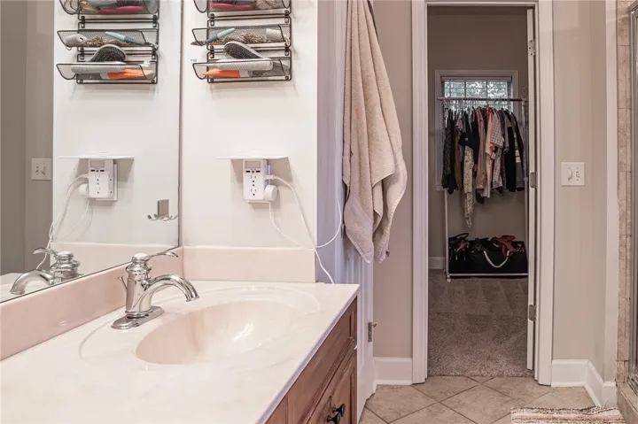 A cream-toned countertop with an integrated sink and chrome faucet offers functional elegance within a well-lit bathroom space.