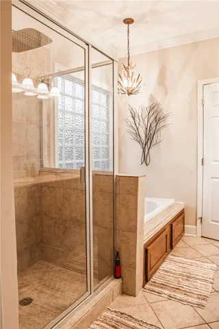 Indulge in a tranquil bathing experience with a tiled walk-in shower and a built-in soaking tub, offering a private retreat.