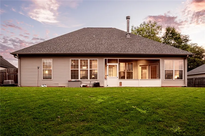 A neatly maintained lawn surrounds the rear of this inviting home, featuring a screened porch perfect for outdoor enjoyment.