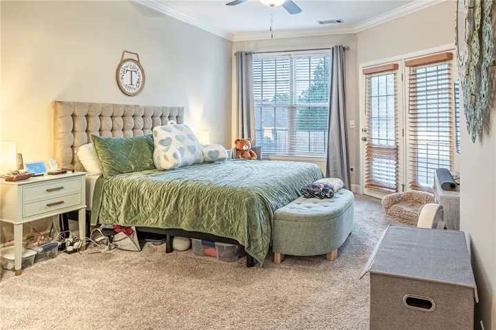 Well-lit sleeping quarters with plush carpeting and direct outdoor access via French doors.
