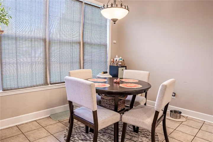 A well-lit dining nook offers a relaxed setting for meals, complete with tiled flooring and ample natural light.
