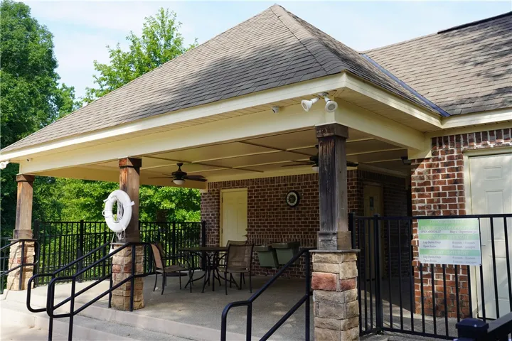 An inviting covered patio offers a comfortable gathering space with ceiling fans and brick construction.