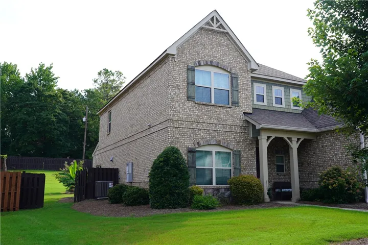 A classic brick facade with decorative shutters and well-kept landscaping defines this inviting residence.