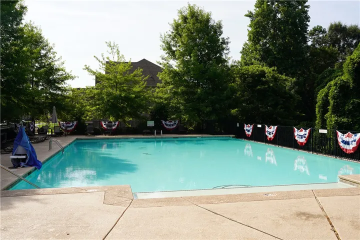 A refreshing outdoor pool, enclosed by a sturdy fence, promises leisure and enjoyment.