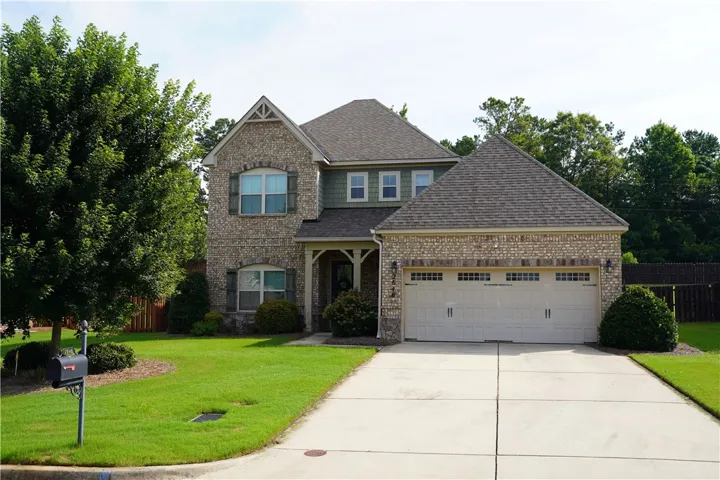An inviting brick and siding home with an attached garage and neatly landscaped front yard awaits.