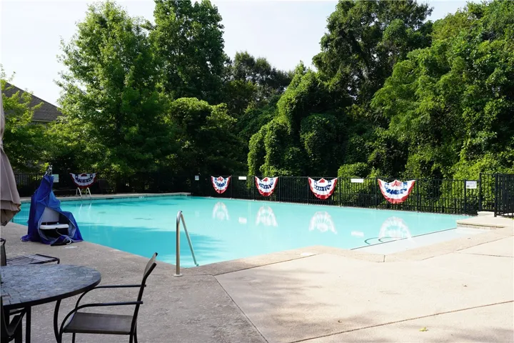 A secluded outdoor swimming pool with surrounding verdant foliage.