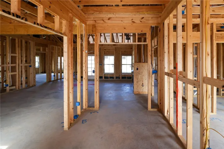 Exposed wood framing and concrete subfloors outline the spacious layout of this home under construction.