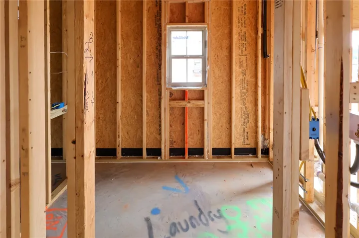 Exposed wood framing and concrete flooring outline the future laundry room space.