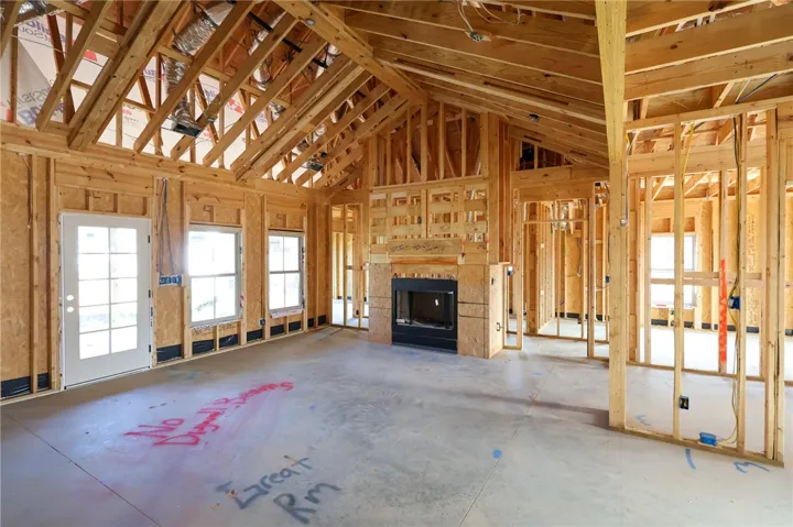 Vaulted ceilings and a central fireplace anchor this spacious unfinished living area during construction.