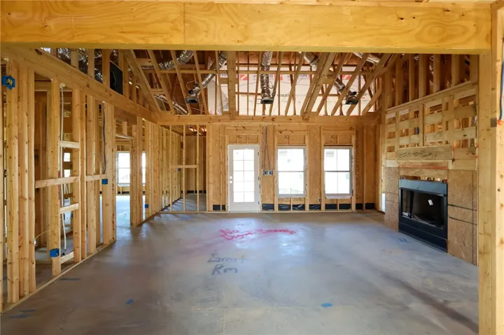 Exposed framing reveals the soaring vaulted ceiling and fireplace placement during construction.