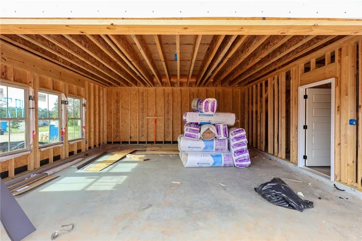 Exposed wood joists and concrete flooring define this spacious garage currently under construction.