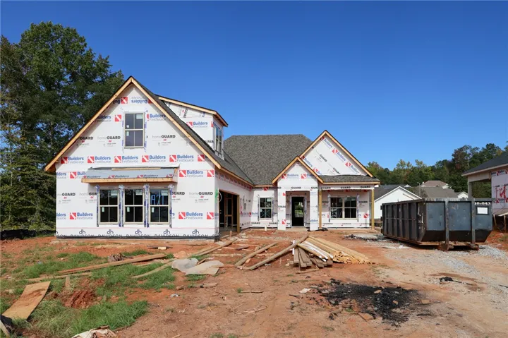 Progress continues on this new construction home featuring multi-gable rooflines and a framed front porch.