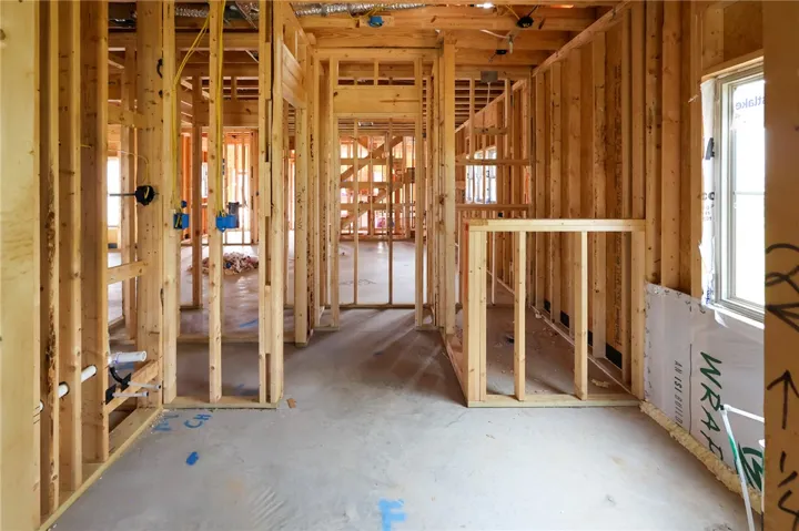 Exposed wood framing and concrete subfloors mark the early stages of this custom interior construction.