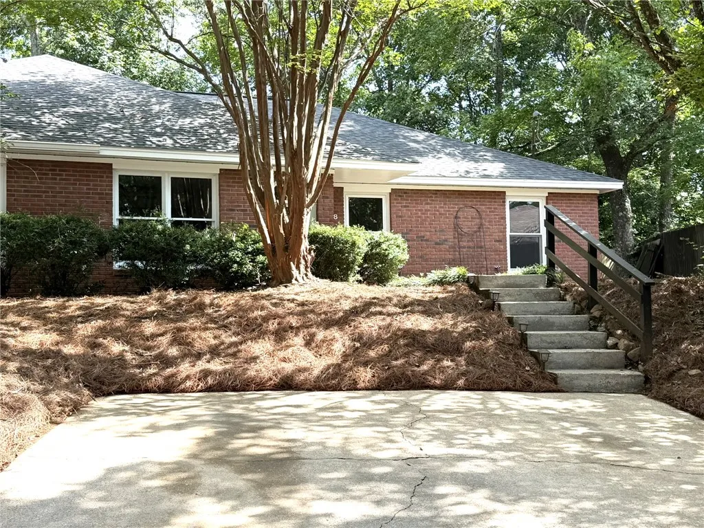 Brick facade and mature landscaping define this inviting curb appeal.