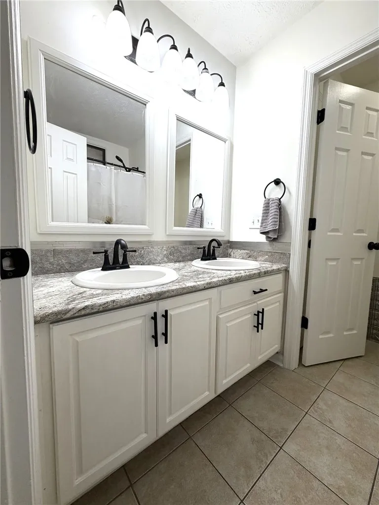 Dual vanities with polished countertops and contemporary fixtures create a functional and pleasant bathroom environment.