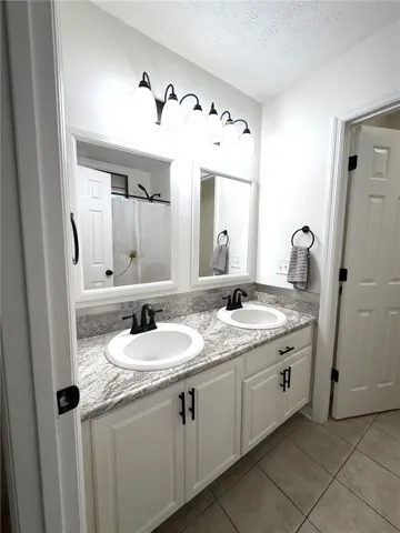 Dual vanities with elegant granite counters offer functionality and style in this well-appointed bathroom.