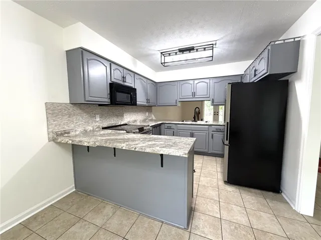 Functional kitchen with ample cabinet space and a convenient breakfast bar.