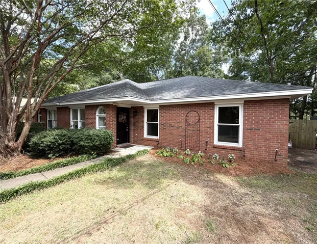 A classic brick exterior, framed by mature trees, welcomes you to this charming residence.