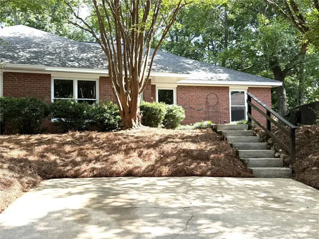 Brick facade and mature landscaping define this inviting curb appeal.