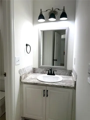 A well-appointed bathroom vanity offers a practical sink set into granite countertops.
