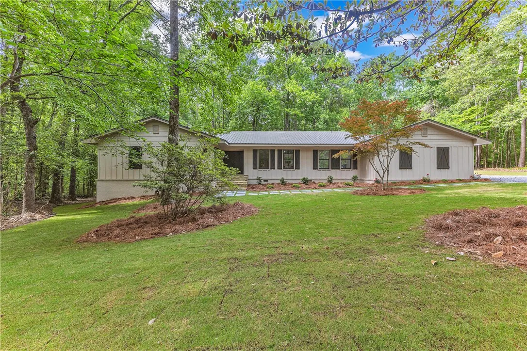 A private, nature-immersed dwelling nestled amidst abundant green foliage and manicured grounds.