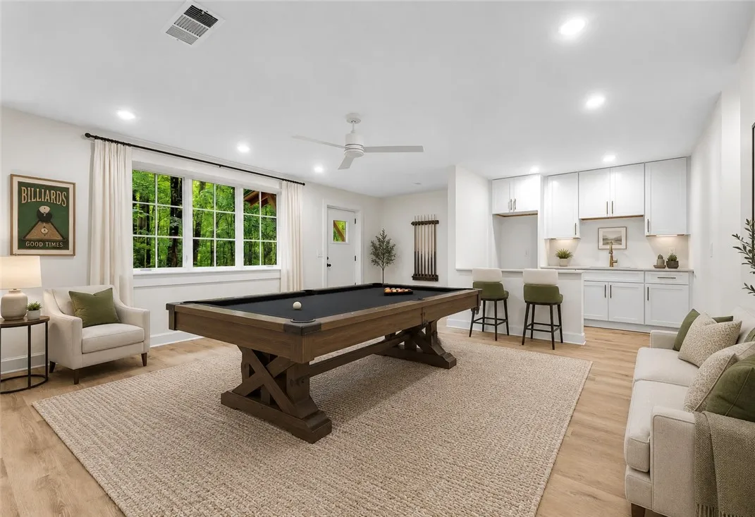 A vibrant game room offers endless entertainment with a full-size billiards table and a convenient wet bar.