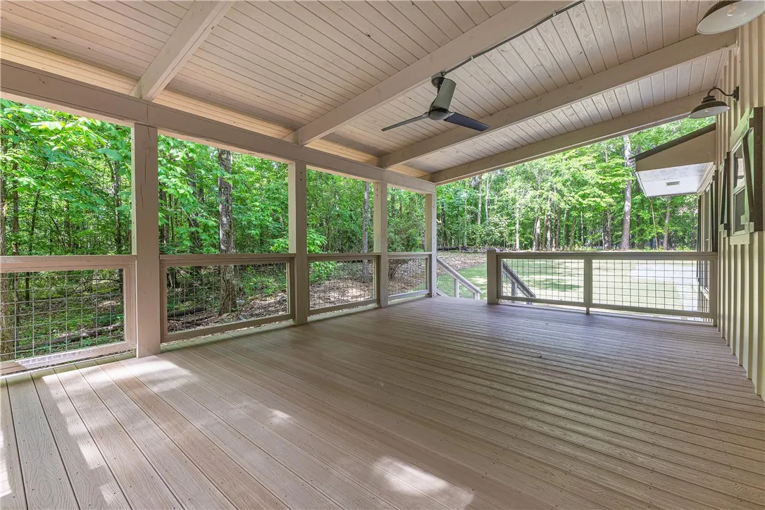 A spacious covered porch overlooks a private, wooded setting.