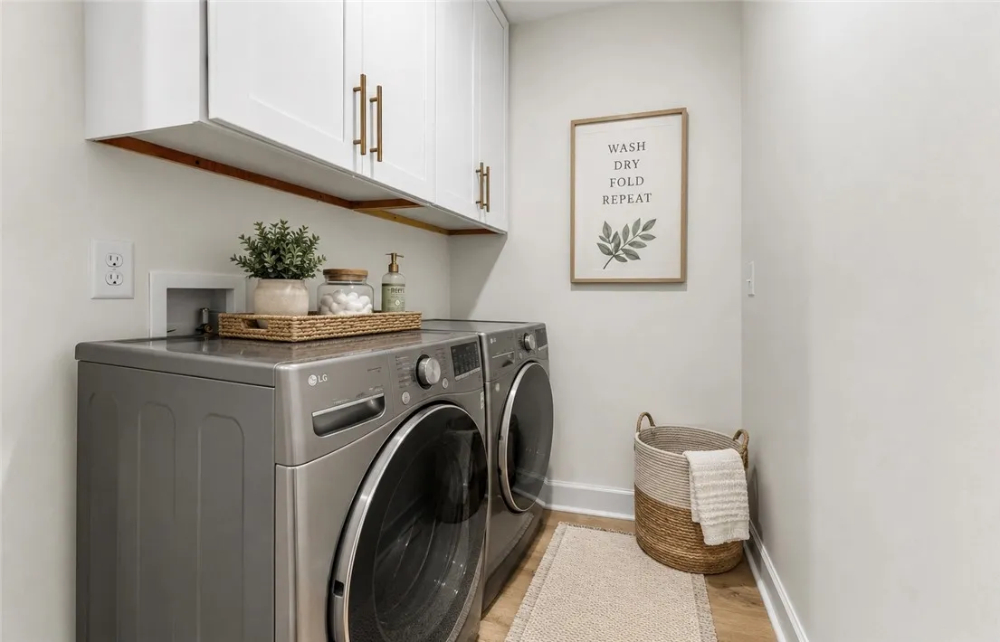 Streamlined laundry room with ample cabinetry offers efficient utility space.