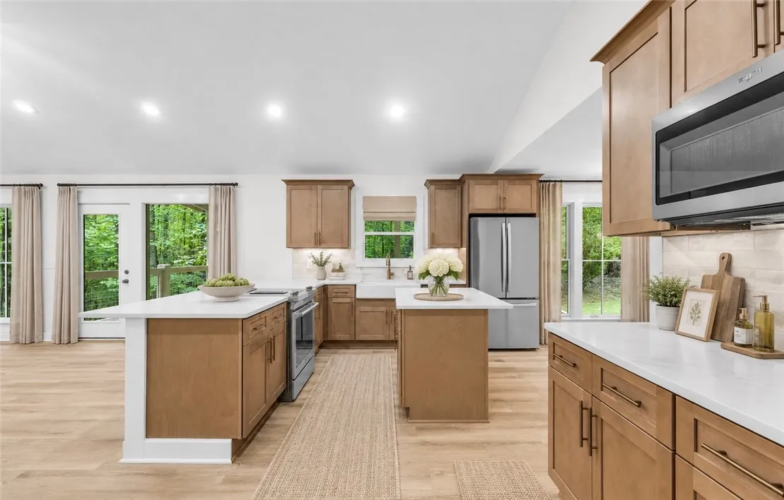 Culinary dreams unfold in this kitchen featuring abundant wood cabinetry and dual islands for prep and entertaining.