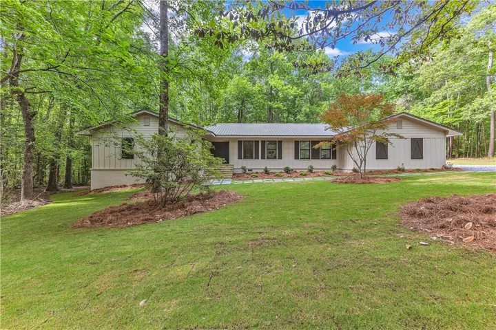 A private, nature-immersed dwelling nestled amidst abundant green foliage and manicured grounds.