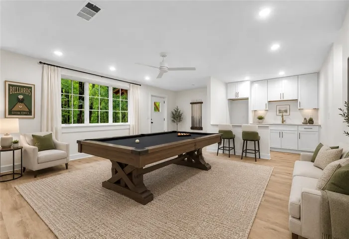 A vibrant game room offers endless entertainment with a full-size billiards table and a convenient wet bar.