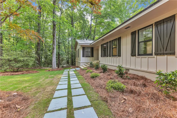 A flagstone pathway leads to the welcoming entry of this charming wooded retreat.