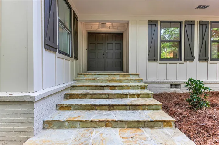 Enter through grand double doors, ascending the stone staircase to this stately home.