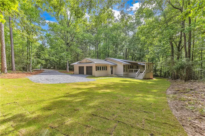 A tranquil wooded setting surrounds this charming home, offering both privacy and a generous yard.