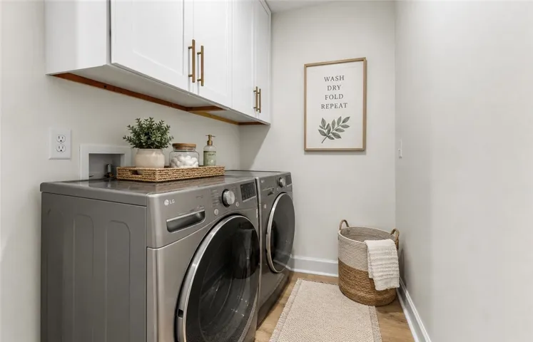 Streamlined laundry room with ample cabinetry offers efficient utility space.