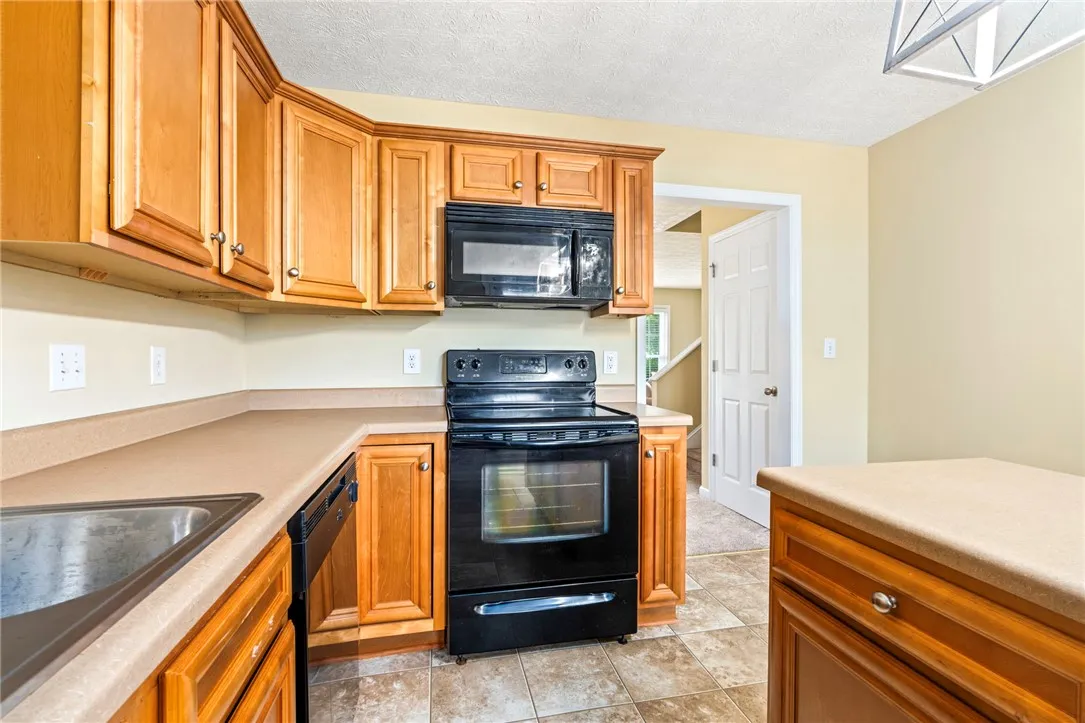 An inviting kitchen with warm wooden cabinetry and durable tile flooring awaits culinary creations.