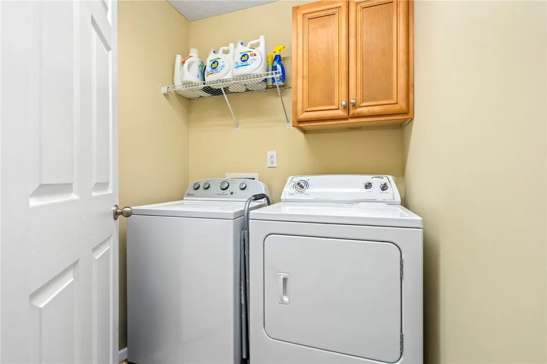 Functional laundry room offers convenient appliances and overhead storage for household essentials.