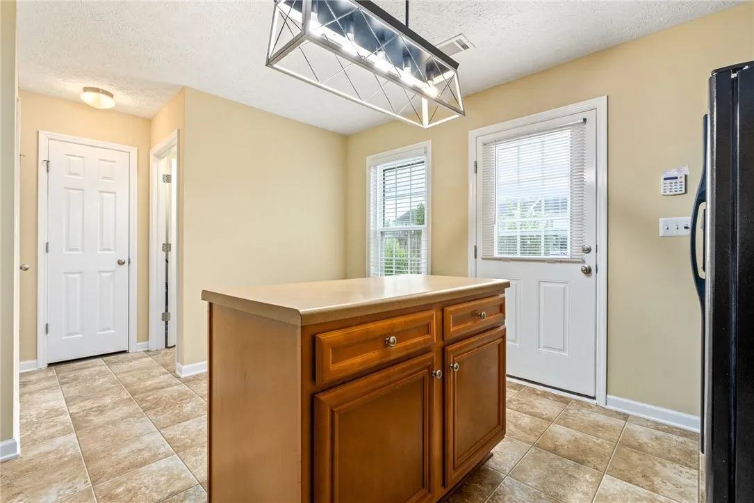 A functional kitchen with a central island offers ample counter space and convenient access to the outdoors.
